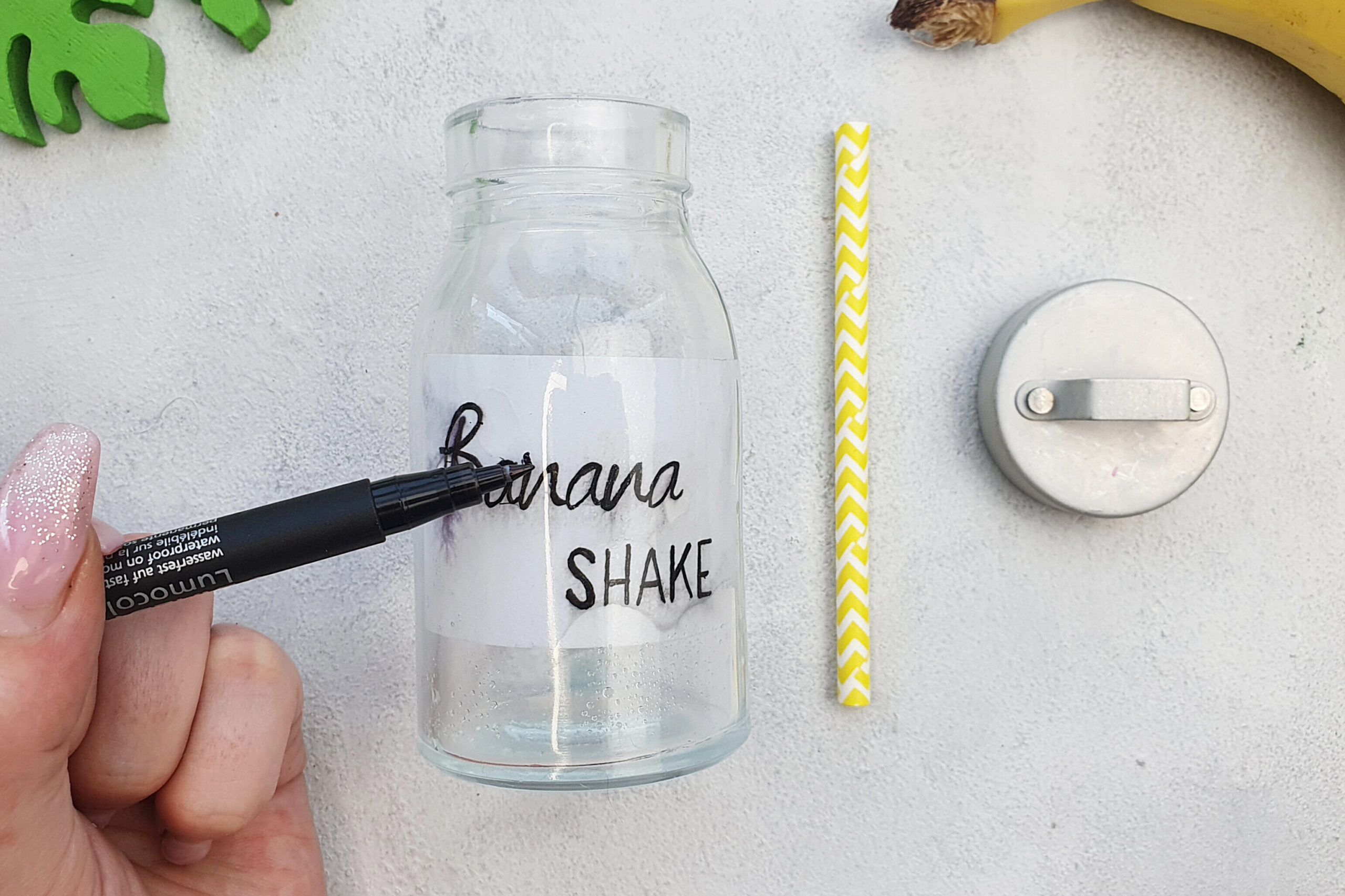 Das Trinkglas wird mit einem Wasserfesten Stift beschriftet, danach wird das Glas mit Bananenshake gefüllt