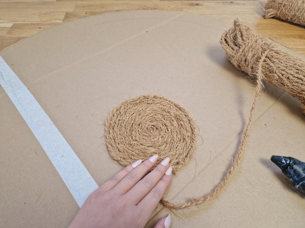Die Bastelidee zeigt, wie das Kokosseil auf die Pappe geklebt wird.